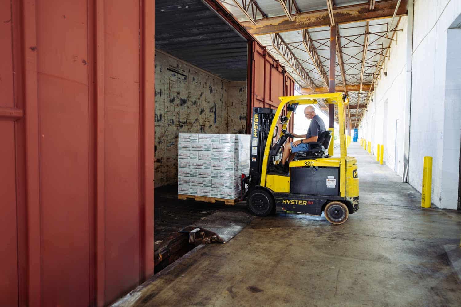 forklift loading product into rail car - Distribution Technology